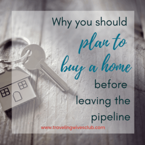 key ring with small home attached laying on wooden floor